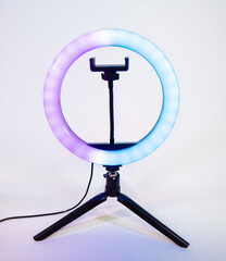 Ring lamp on a small tripod. Purple and blue light.