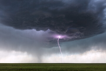 Fototapeta na wymiar Thunderstorm lightning bolt over a field