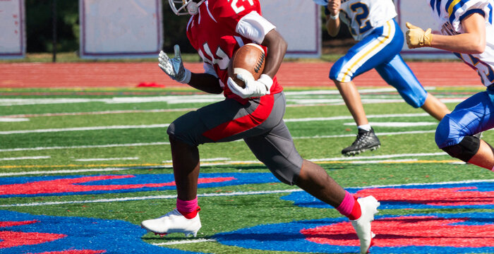 Football Running Back Being Chased By Defensive Players Down The Field