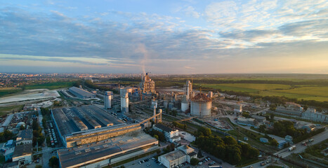 Fototapeta premium Aerial view of cement factory tower with high concrete plant structure at industrial production area. Manufacturing and global industry concept