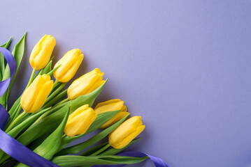 Top view photo of woman's day composition bouquet of yellow tulips and purple ribbon on isolated pastel lilac background with empty space