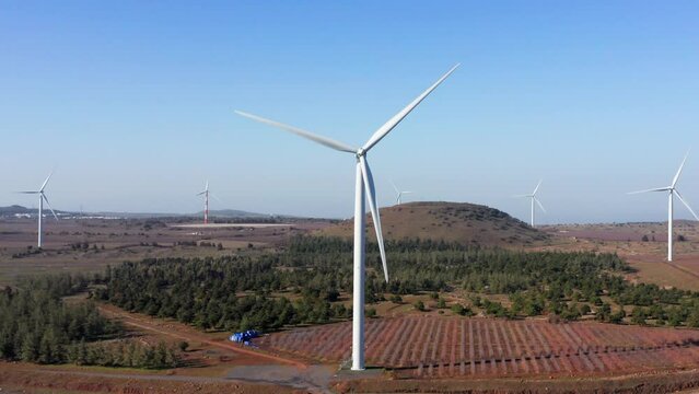 Wind turbines spin in a rural mountain landscape, Aerial view.