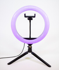 Ring lamp on a small tripod. Purple light.