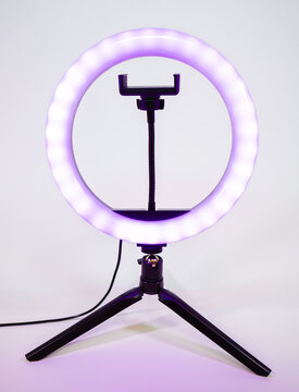 Ring lamp on a small tripod. Purple light.