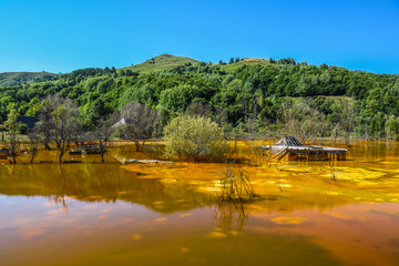 Mountain lake landscape - liquid residues from a gold mine discharged into a lake, pollution