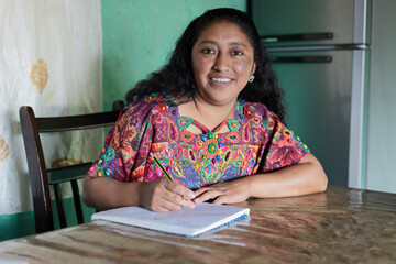 Hispanic adult woman studying at home - family mother handling household finances - Mayan woman...
