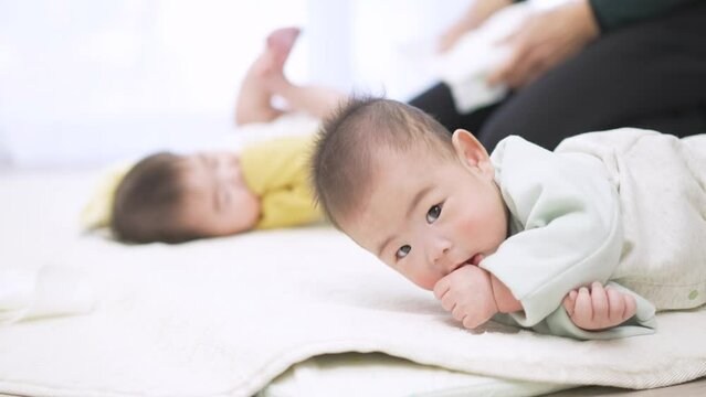寝返りをするアジア人の赤ちゃん