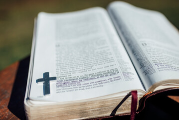 Fototapeta premium Close up view of Bible verse with metal cross