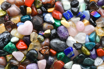 A top view image of a large variety of chakra healing crystals with rose quartz crystal heart. 