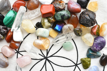 A close up image of a variety of healing crystals with sacred geometry grid cloth. 