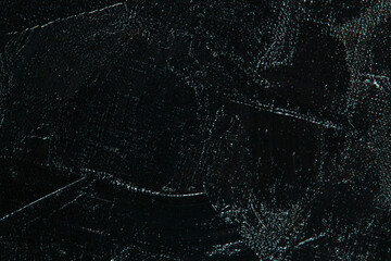 Dark creative background - rough linen canvas unevenly covered with black primer, reflections of light. Toning, blurring, selective focus.