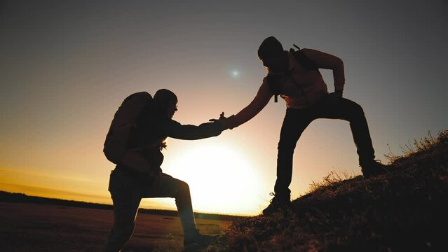teamwork. help travel silhouette concept. group team of tourists lends helping hand climb the cliffs mountains. adventure people teamwork climbers business climb to top helping hand hardships path
