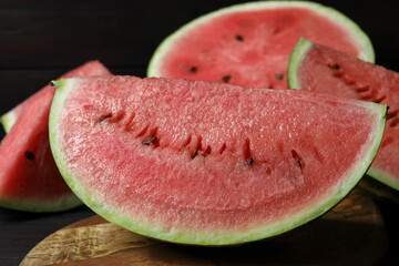 Slices of tasty ripe watermelon on wooden board, closeup