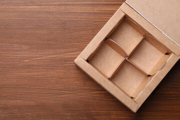 Empty candy box on wooden background, top view. Space for text