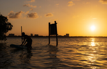 Boy doing kayaking in a lagoon at sunset