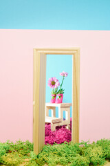Surreal composition of  open door,pink women shoes filled with violet flowers and violet moss. Contemporary Spring still life.