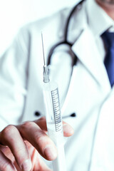 Vaccine dose medical injection. Selective focus, hospital white doctor gown, stethoscope. Nurse hand in blue gloves holding syringe with needle. Liquid drug or narcotic. Health care in hospital.