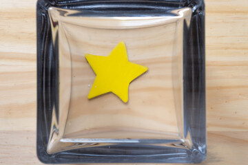 painted star in a upside down glass jar on a wooden surface