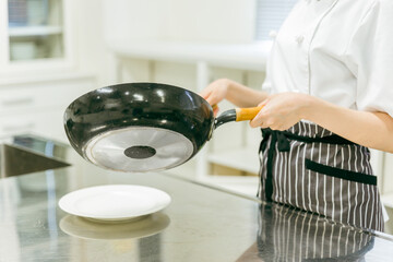 フライパンで料理する女性（手元）
