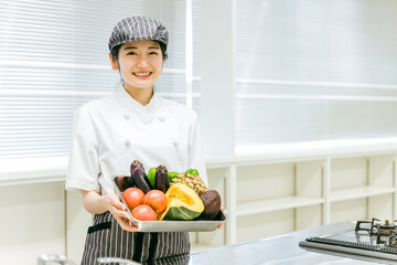 野菜を持つ調理師（笑顔）
