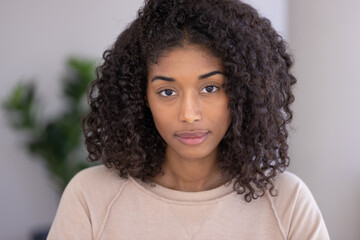 Young black woman serious face portrait at home