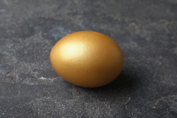 Golden egg on black table, closeup view