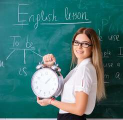The young female english language teacher standing in front of t