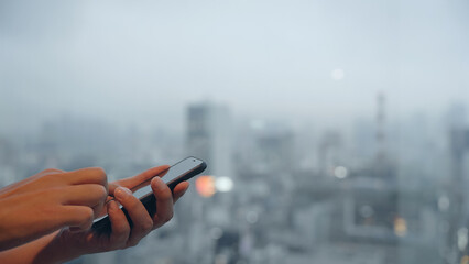 都市を背景にスマホを使う男性