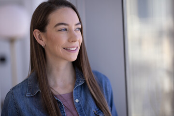 Caucasian woman smiling happy face portrait standing by a window