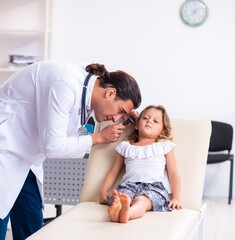 Fototapeta na wymiar Young doctor pediatrician with small girl
