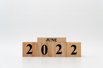 June 2022 written on wooden blocks isolated on white background with copy space