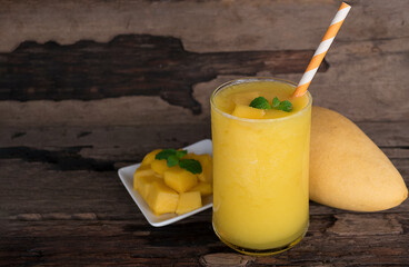 Mango juice fruit smoothies yogurt drink yellow healthy delicious taste in a glass slush for weight loss on wooden background.