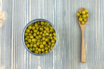 A jar of canned green peas on the table.