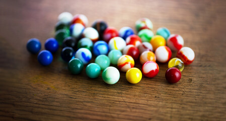 Many color variations of vintage marbles. Beautiful vintage marbles rolled out on a old wooden table. Extremely shallow depth of field.