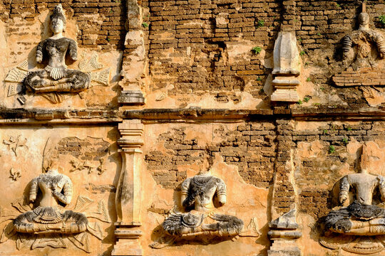 Old stucco Buddha and angel figures on the outside of the Maha Chedi of Wat Chet Yot (Wat Jed Yod) or Wat Photharam Maha Vihara, the public Buddhist temple. Located in Chiang Mai, Thailand.