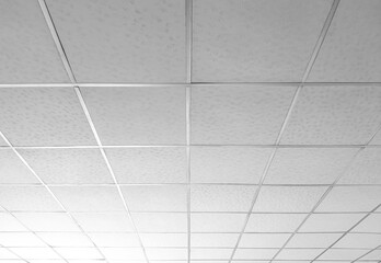 Background and texture of white T bar ceiling tiles with nice light gradation in low angle and perspective view - obrazy, fototapety, plakaty