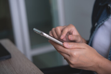 Close up of young asian woman hands holding and using mobile smart phone