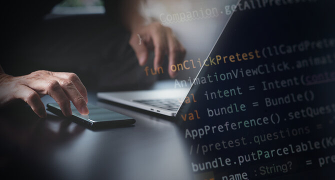 Software development, developing programmer coding javascript on laptop computer and using mobile phone for mobile apps design in software company office, digital technology