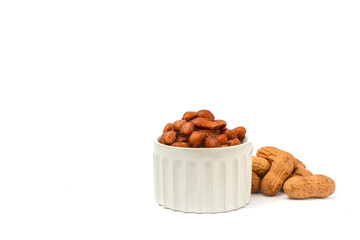 Peanuts in shell and peanuts unshelled in bowls on the white background with space for text.