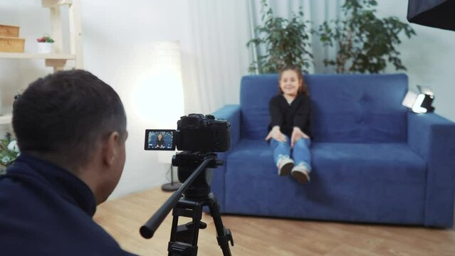 kid video blogger. videographer shoots a video blog in a studio with a little girl for an online platform. kid dream blogger records vlog backstage on camera. little youtuber girl