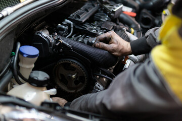 Fototapeta na wymiar Close up hands of auto mechanic doing car service and maintenance. Services car engine machine.