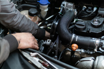 Close up hands of auto mechanic doing car service and maintenance. Services car engine machine.