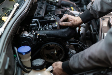 Close up hands of auto mechanic doing car service and maintenance. Services car engine machine.