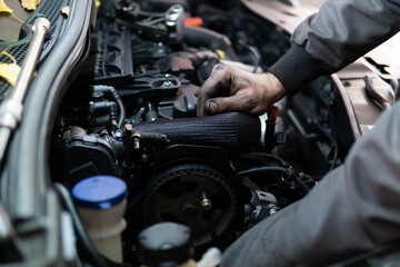Close up hands of auto mechanic doing car service and maintenance. Services car engine machine.