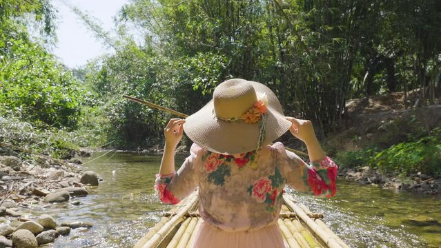 Asian women traveler on bamboo rafting  scenic river forest.