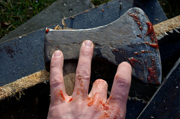 camping skills father with son. chopping wood logs from willow in autumn. the father shows with ax what can happen like cutting off an arm, fingers, foot. in the background wooden beehives beekeeper