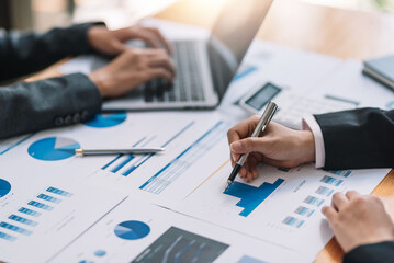 Business people sitting at desk doing paperwork together discussing project financial report. Corporate business collaboration concept.