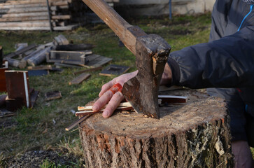 man injured with ax while working with wood for heating. blood and severed fingers in a pile of cut...