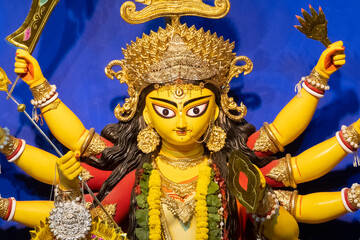 Face of Goddess Durga idol at decorated Durga Puja pandal, shot at colored light, at Kolkata, West...