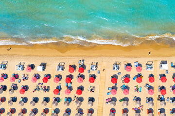 Zakynthos Island, Greece. Top view aerial drone photo of Banana beach with beautiful turquoise water, sea waves and red umbrellas. Vacation travel background. Ionian sea